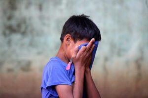 Sad child hiding his face photo by Lucas Metz